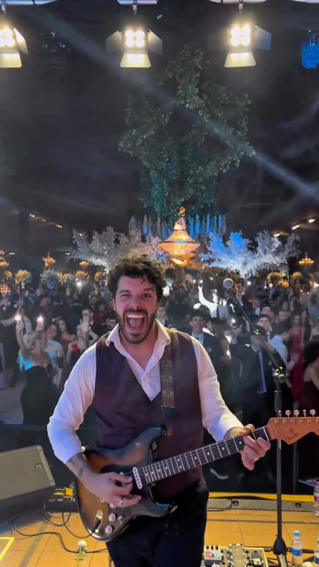 Bruno Bonafini cantando ao microfone com guitarra, em preto e branco